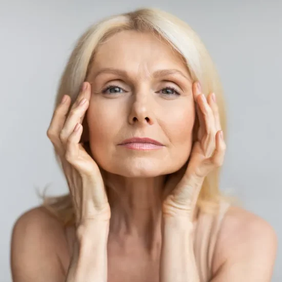 antiage-skincare-senior-woman-touching-skin-near-eyes-looking-camera-lady-with-flawless-skin